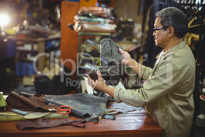 Shoemaker examining a leather boot