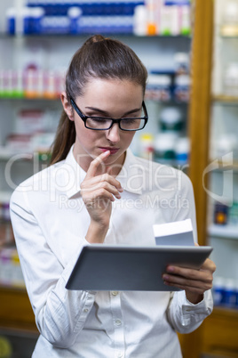 Pharmacist using digital tablet while checking medicine Pharmacist using digital tablet while checking medicine