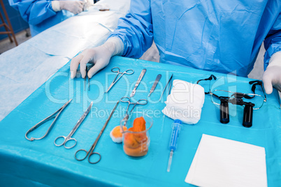 Surgeon with surgical tool on tray in operation room
