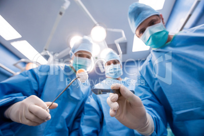 Surgeons holding surgical tools and cotton