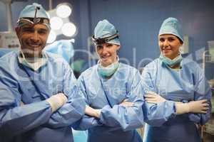 Portrait of surgeon and nurses standing with arms crossed in ope