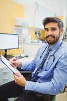 Portrait of doctor writing on a clipboard