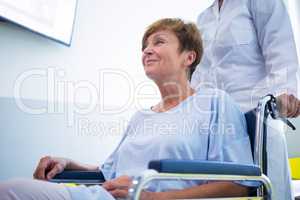 Doctor pushing senior patient on wheelchair