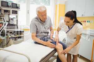 Female doctor examining patients knee
