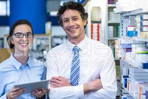 Pharmacists using digital tablet in pharmacy