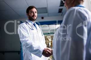 Doctors shaking hands in corridor