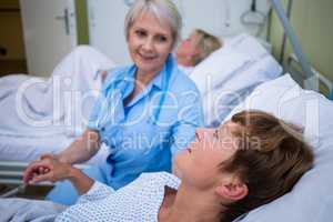 Nurse examining patients pulse