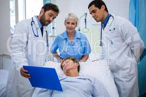 Doctors showing medical report to patient