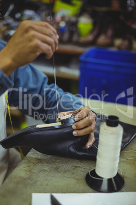 Shoemaker stitching shoe sole with needle