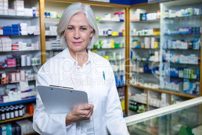 Pharmacist holding a clipboard in pharmacy