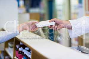 Pharmacist giving a box of medicine to customer