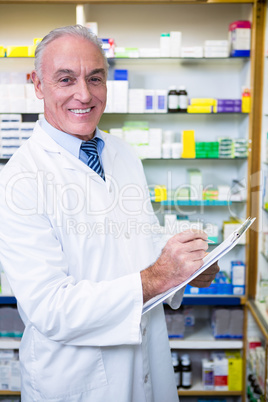 Pharmacist writing on clipboard