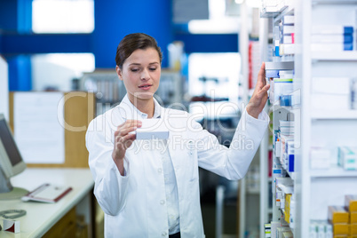 Pharmacist checking medicine in shelf Pharmacist checking medicine in shelf