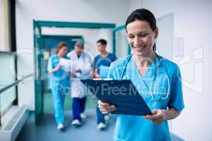 Smiling surgeon holding a clipboard at hospital