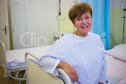 Portrait of smiling senior patient sitting on a bed