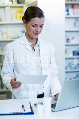 Pharmacist making prescription record in laptop