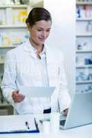 Pharmacist making prescription record in laptop