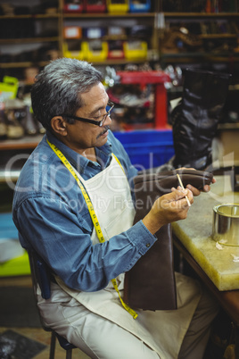 Shoemaker applying glue on shoe