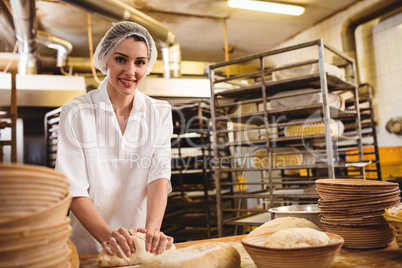 Female baker kneading a dough