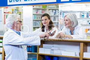 Pharmacists standing at counter and interacting with each other