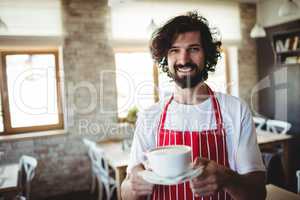 Male baker holding a cup of coffee