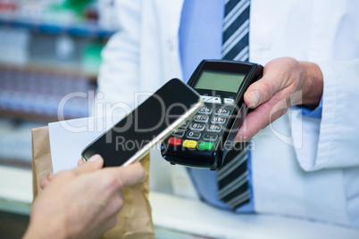 Customer making payment through smartphone in payment terminal