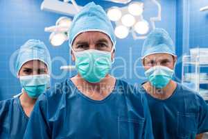 Portrait of surgeon and nurses standing in operation room