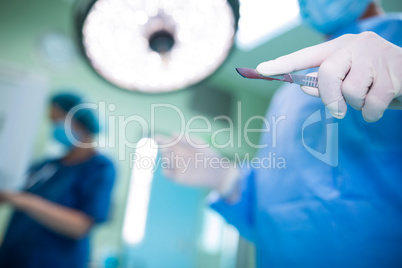 Surgeon holding surgical tool in operation room