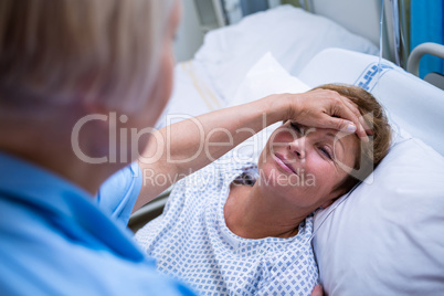 Nurse checking patient temperature