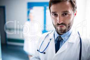 Confident doctor standing in hospital corridor