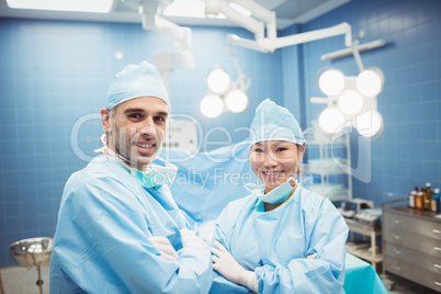 Portrait of surgeon and nurse standing with arms crossed in oper