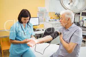 Female doctor checking blood pressure of patient