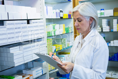 Pharmacist writing on clipboard