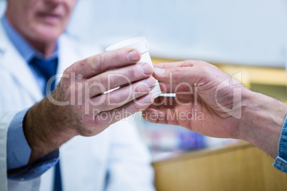 Pharmacist giving medicine to customer