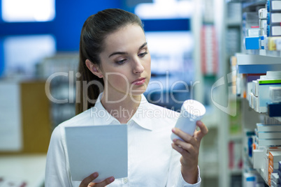 Pharmacist holding prescription while checking medicine