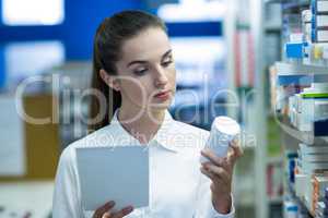 Pharmacist holding prescription while checking medicine