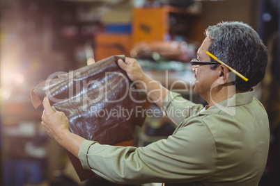 Shoemaker examining a piece of leather