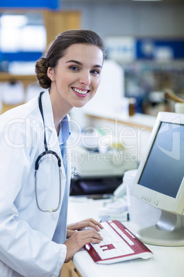 Pharmacist working on computer in pharmacy