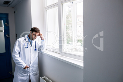 Sad doctor standing in corridor