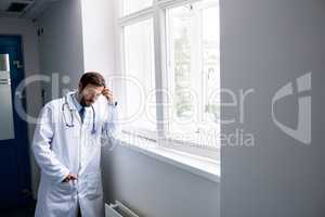 Sad doctor standing in corridor