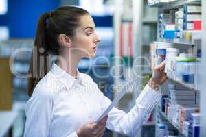 Pharmacist holding prescription while checking medicine