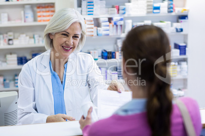Pharmacist giving prescriptions of medicine to customer