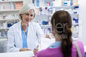 Pharmacist giving prescriptions of medicine to customer