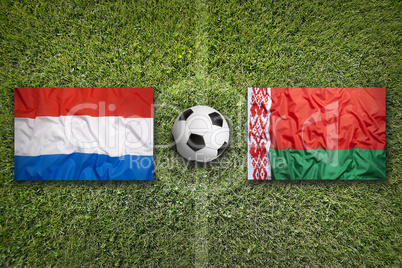 Netherlands and Belarus flags on soccer field