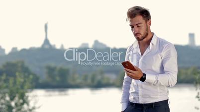 Young businessman talking on mobile phone outdoors