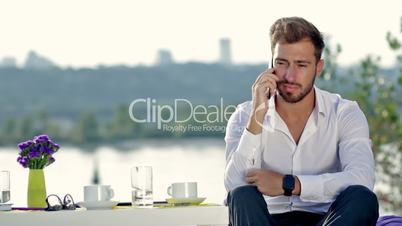 Handsome man talking on the phone outdoors