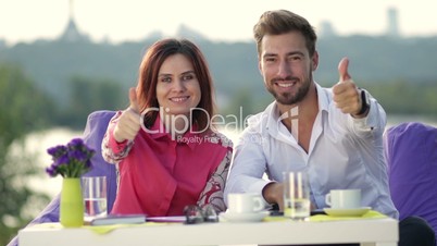 Smiling business people giving thumbs up sign