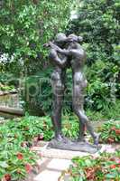 Loving couple embraces. Monument in the park.