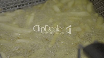 Slow-motion of french fries in the deep fryer. SLOG3, close up.
