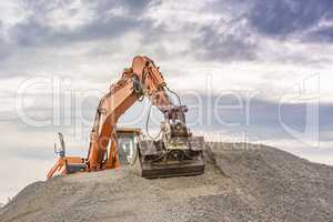 Excavator on top of a ballast pile